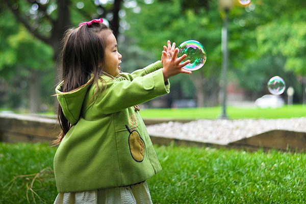 Little Girl Catching Bubble