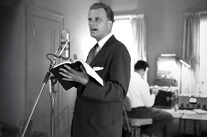 Billy Graham Preaching Into a Radio Microphone with Bible 