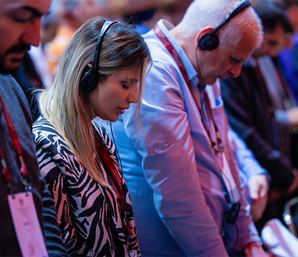 People Praying while Listening to the Gospel on Translation Headphones
